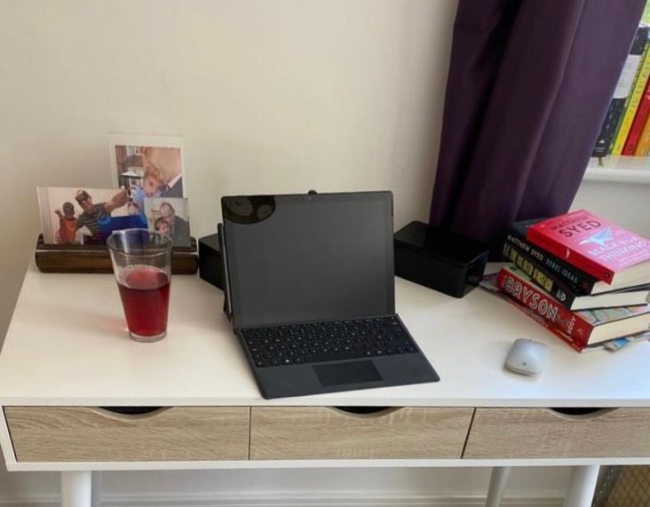 Laptop on desk with books and family photos
